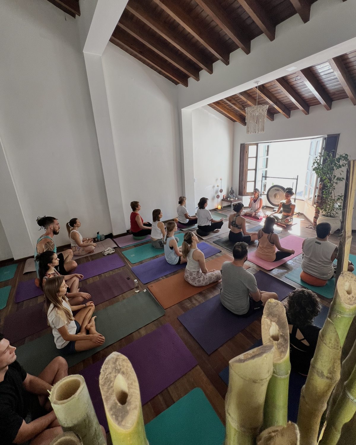 Una clase en el salón de Kundala Yoga Studio, sentados sobre sus mats